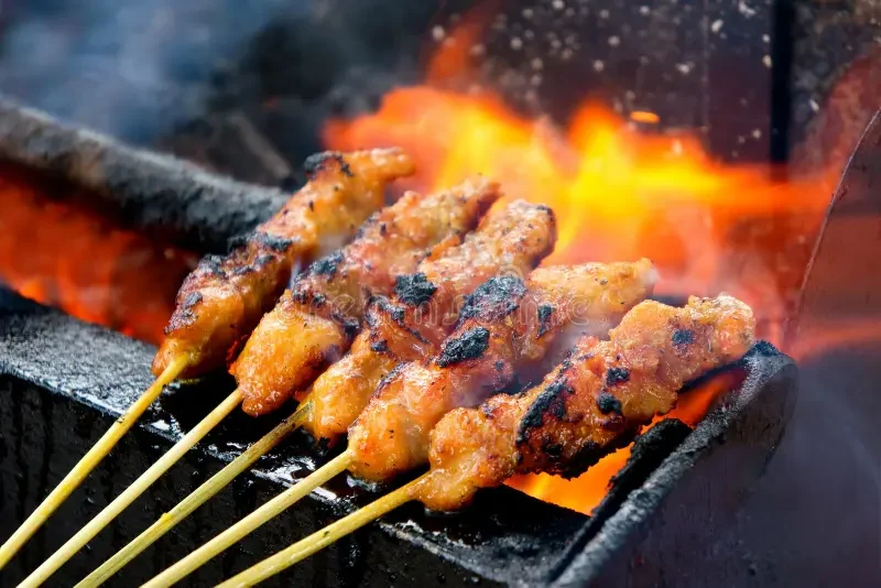 Illustrative reference photo of satay grilling over charcoal; not verified as Mors Satay food